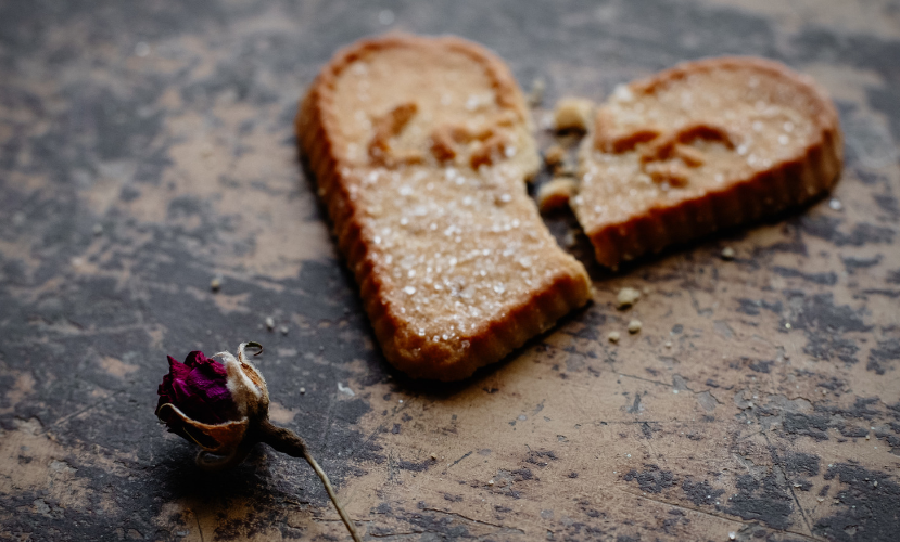 a heart shape broken cookie and a withered rose