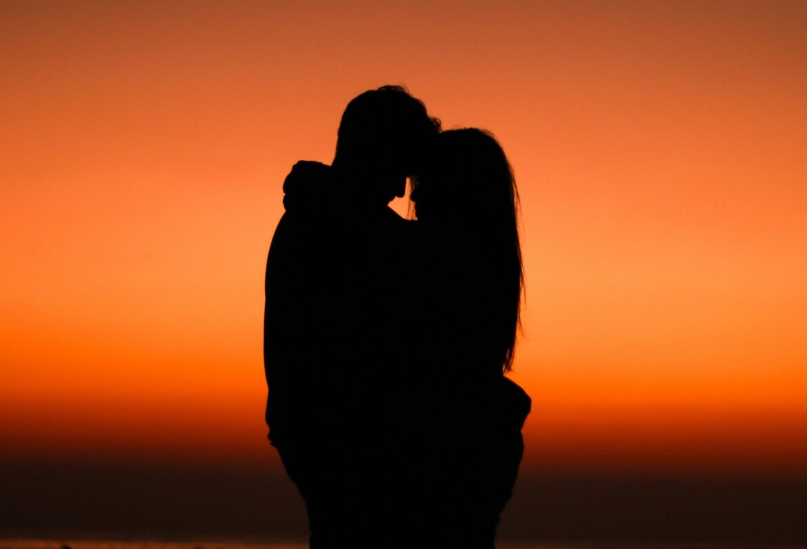 couple hugging with sunset backdrop