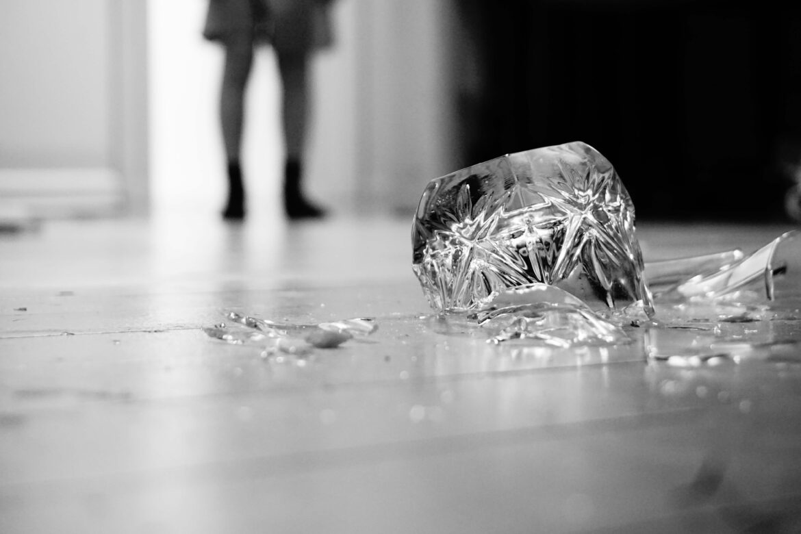 grayscale of a broken glass on the floor