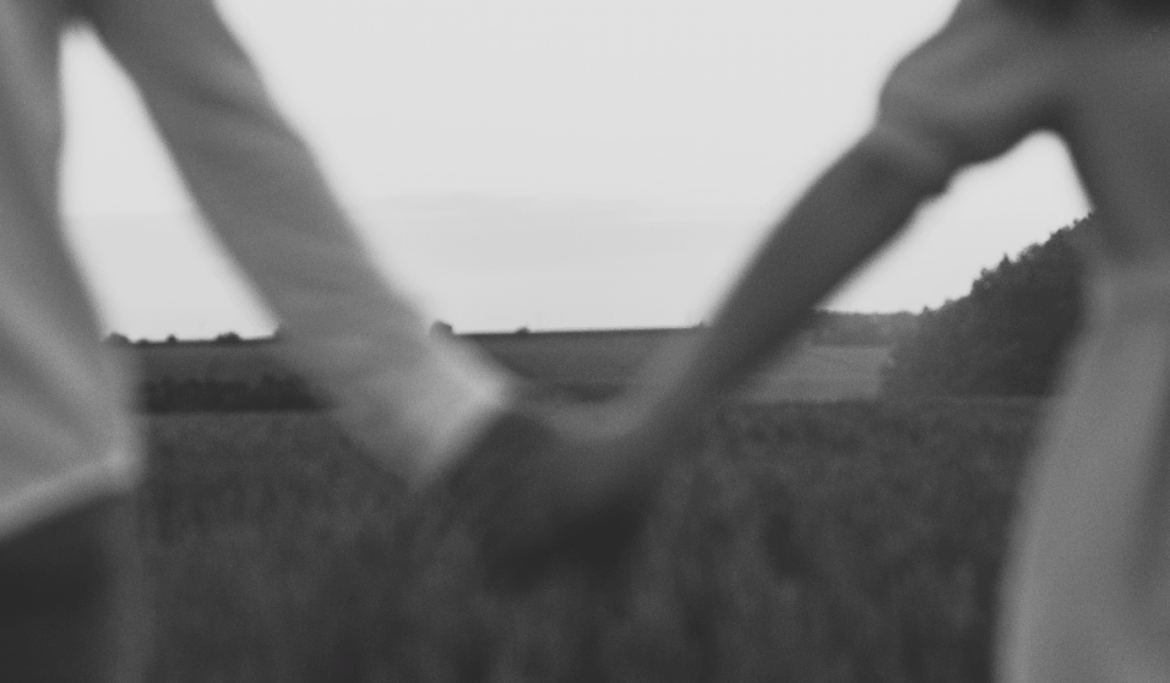 grayscale couple holding hands