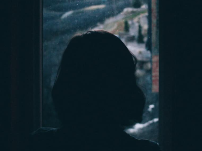 woman looing out the rain at her window