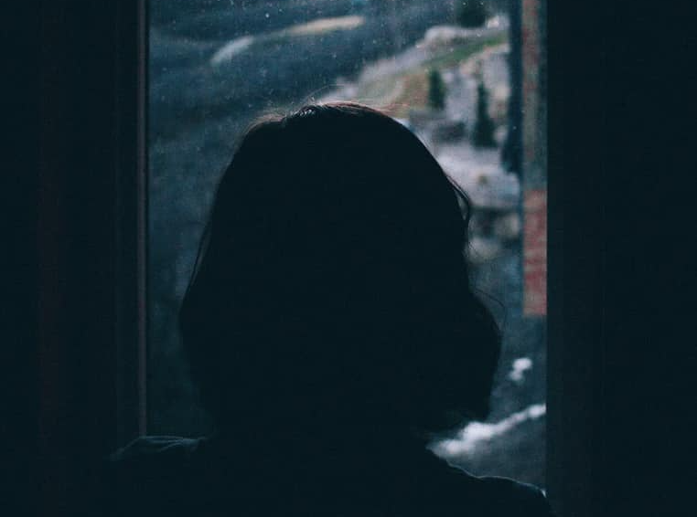 woman looing out the rain at her window