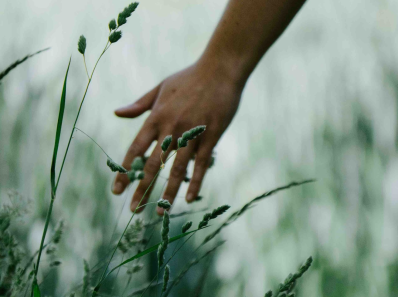 woman walking and touching grass
